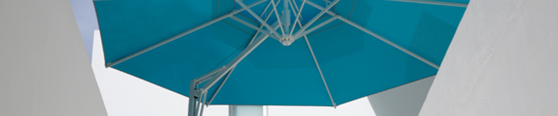 Blauer Sonnenschirm über weißem Stuhl und Tisch und Treppe.